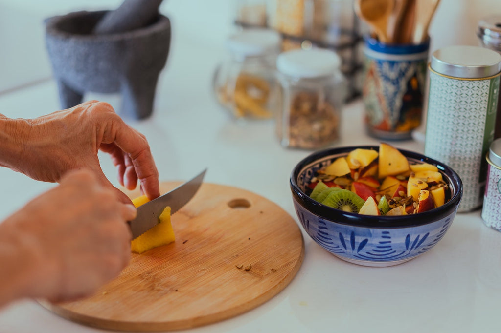 knife cutting fruit on a chopping board